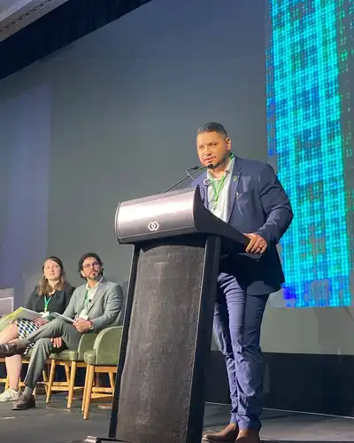 Benjamin Mitchell speaking at a lectern on a conference stage